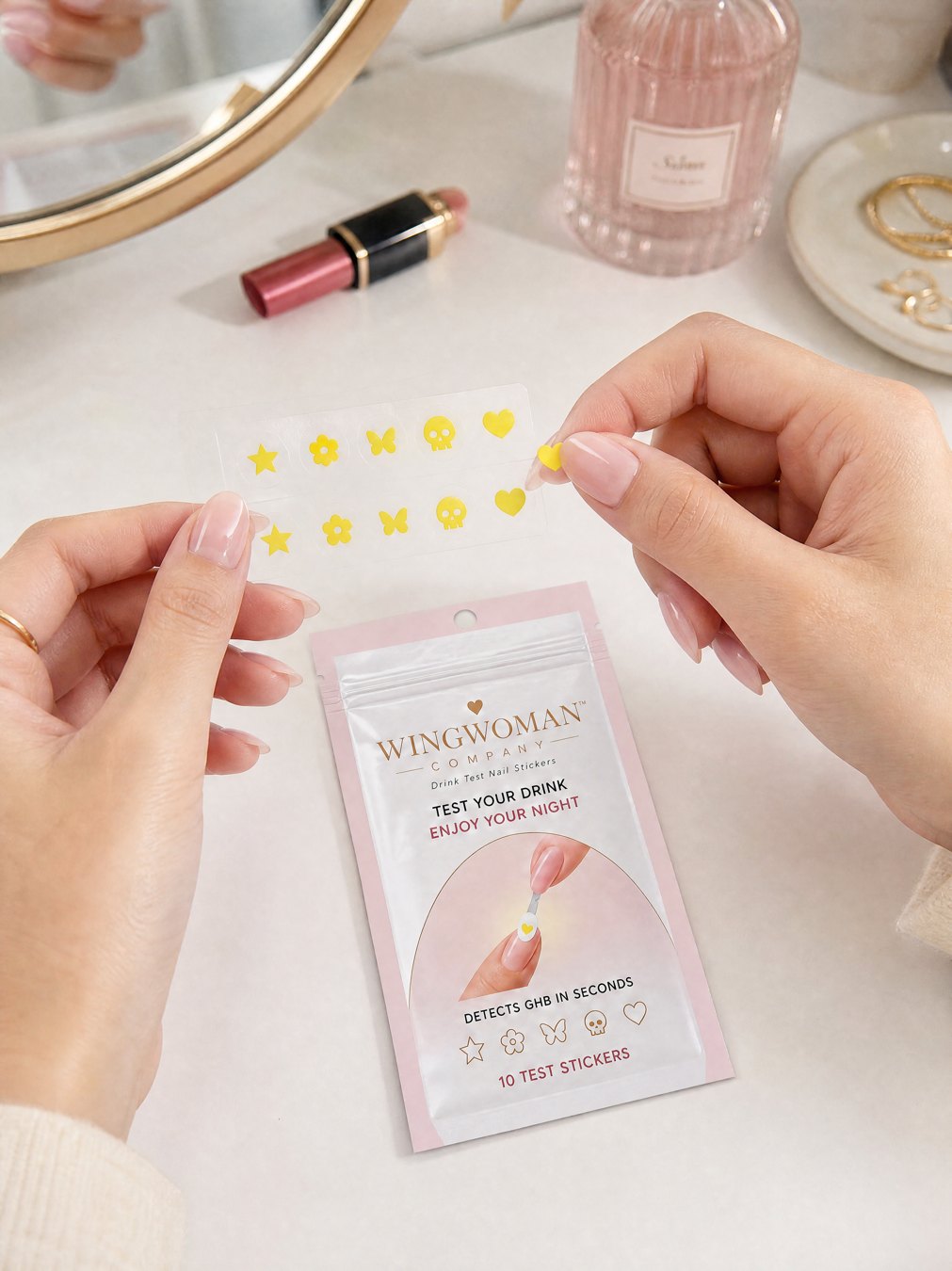 Peeling a tiny yellow heart sticker onto her nail at the vanity