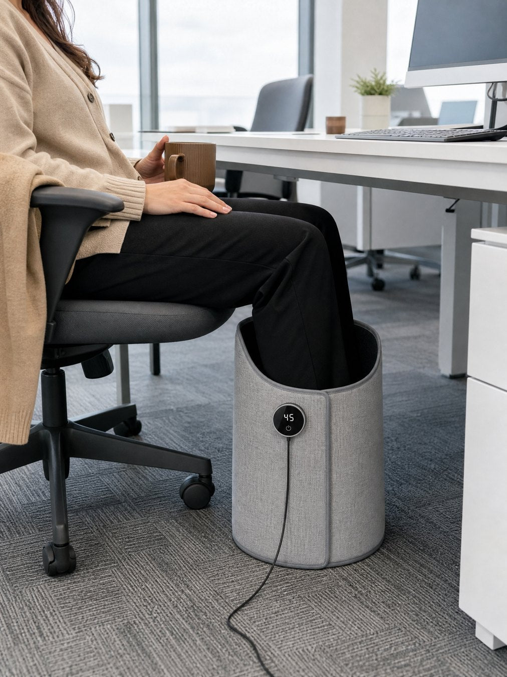 A woman at a freezing office with the heater around her legs under the desk